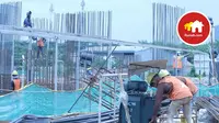 Sejumlah tukang tengah mengerjakan proyek pembangunan apartemen.