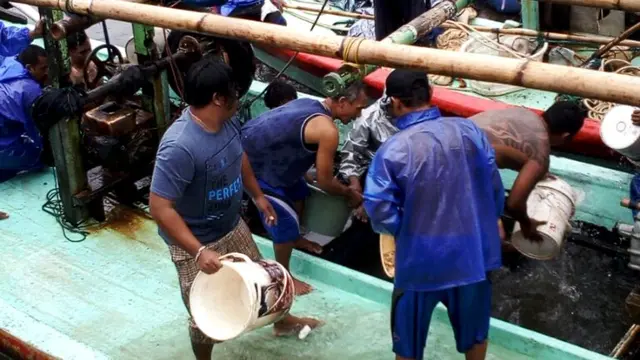Nelayan menguras perahu yang penuh dengan air agar tak tenggelam. (Foto: Liputan6.com/Muhamad Ridlo)