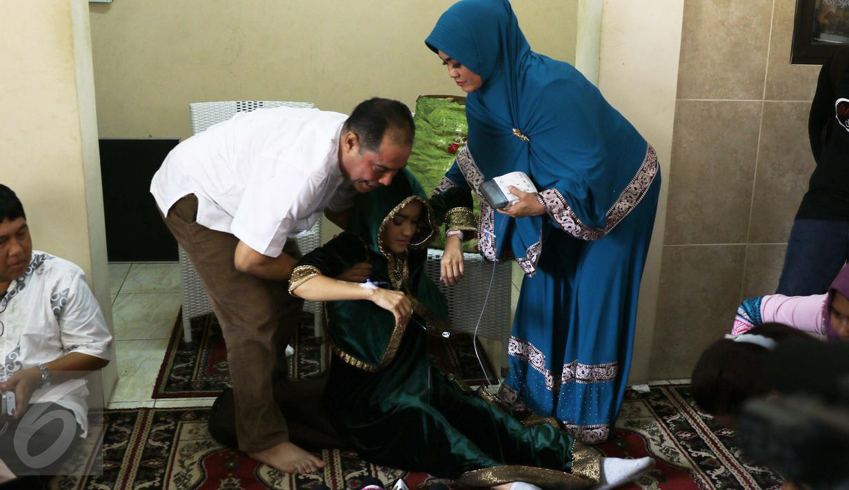 Pedangdut Julia Perez atau Jupe dibantu berdiri usai mengikuti pengajian di kediaman ibunya, Sri Wulansih, di Kelapa Dua, Depok, Kamis (29/12). Sebelum datang ke pengajian, Jupe diketahui sedang menjalani kemoterapi di RSCM. (Liputan6.com/Herman Zakharia)