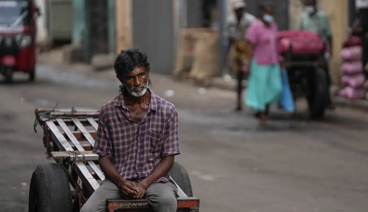 Seorang pekerja upahan harian menunggu pekerjaan di pasar grosir di Kolombo, Sri Lanka, Minggu (26/6/2022). Sri Lanka bangkrut dengah beban utang yang besar, kehilangan pendapatan pariwisata dan efek lain dari pandemi Covid-19, serta melonjaknya biaya komoditas. (AP Photo/Eranga Jayawardena)