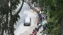 Orang-orang mengantre di stasiun pengumpulan spesimen bergerak untuk pengujian Covid-19 di distrik Tung Chung, Hong Kong pada 10 Februari 2022. Antrean terjadi ketika pihak berwenang bergegas untuk meningkatkan kapasitas pengujian menyusul rekor jumlah infeksi baru yang tinggi. (Peter PARKS / AFP)