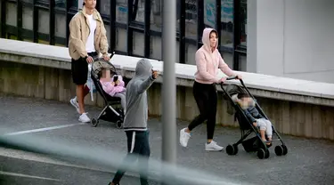 Cristiano Ronaldo bersama Georgina Rodriguez mendorong dua kereta bayi saat mereka berjalan-jalan dengan anak-anak mereka di Funchal pada 28 Maret 2020. Pesepakbola Cristiano Ronaldo dan kekasihnya, Georgina Rodriguez membagikan kabar duka. (AFP/HELDER SANTOS)