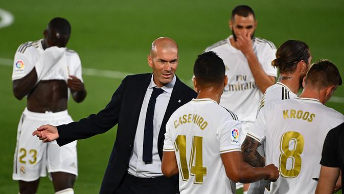Pelatih Real Madrid, Zinedine Zidane, memberikan arahan kepada pemainnya saat melawan Getafe pada laga lanjutan La Liga pekan ke-33 di Stadion Alfredo Di Stefano, Jumat (3/7/2020) dini hari WIB. Real Madrid menang 1-0 atas Getafe. (AFP/Gabriel Bouys)