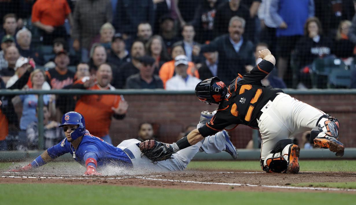 Pemain Chicago Cubs, Javier Baez (kiri) meluncur untuk meraih base saat diadang pemain San Francisco Giants, Buster Posey pada lanjutan MLB di di San Francisco, (7/8/2017). San Francisco kalah 3-5 dari Cubs. (AP/Marcio Jose Sanchez)