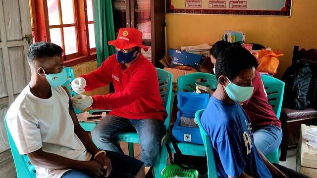 Warga Dusun Glak, saat mendapatkan vaksinasi yang di gelar Badan Intelijen Negara di halaman kantor desa Hale, Kabupaten Sikka, NTT` (Foto Istimewah)