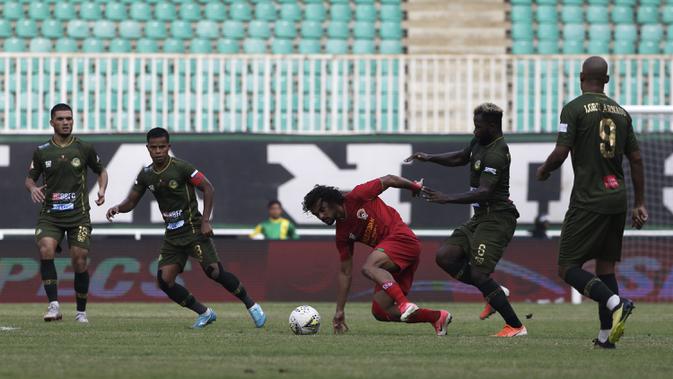 Gelandang Kalteng Putra, Hedipo Gustavo, berebut bola dengan pemain Tira Persikabo pada laga Shopee Liga 1 di Stadion Pakansari, Bogor, Jumat (26/7). Tira Persikabo menang 5-2 atas Kalteng. (Bola.com/Yoppy Renato)