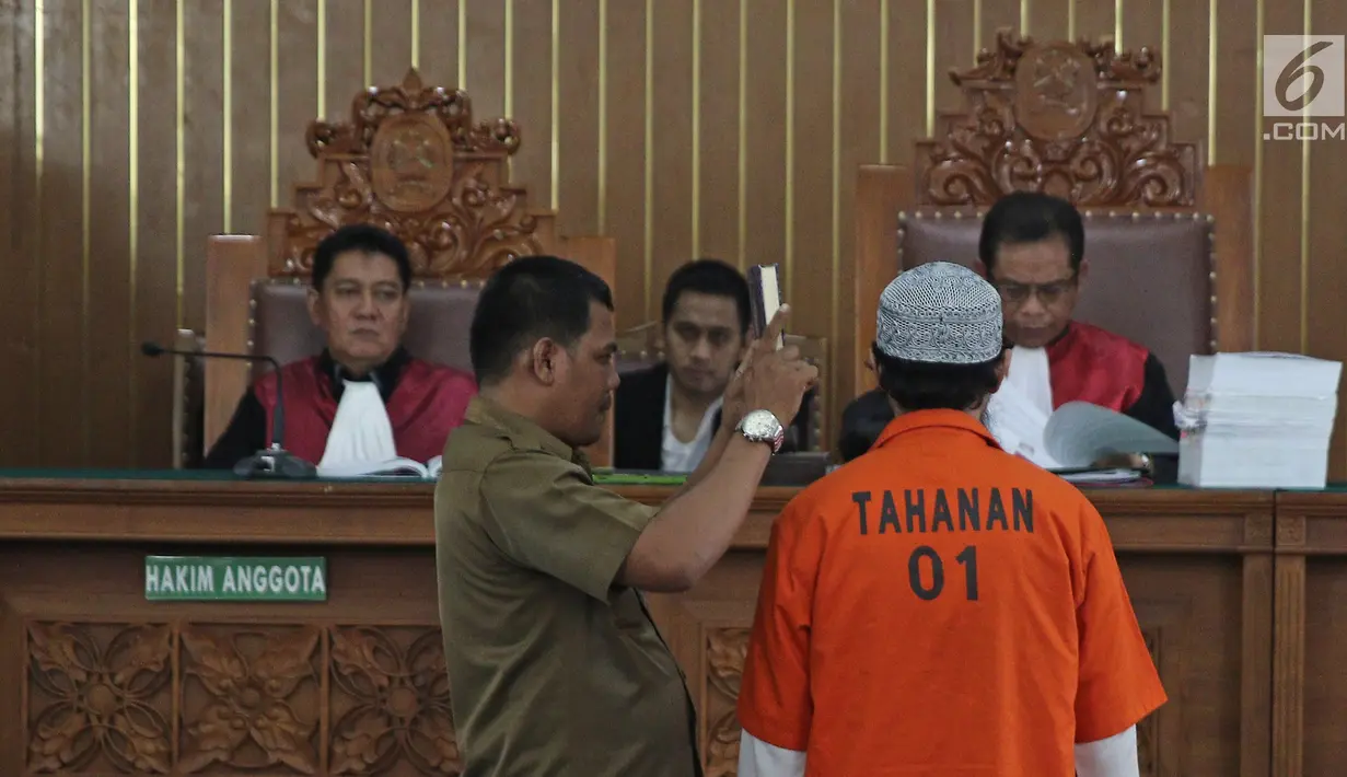 Terpidana kasus pelemparan bom molotov ke Gereja Oikumene, Samarinda, Joko Sugito disumpah sebelum memberikan keterangan pada sidang lanjutan terdakwa bom Thamrin, Aman Abdurrachman di PN Jakarta Selatan, Selasa (27/3). (Liputan6.com/Herman Zakharia)