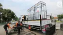 Relawan Dompet Dhuafa memasang tangga untuk masyarakat yang akan menggunakan bilik disinfektan chamber di CheCk Point PSBB, perbatasan Jakarta - Tangsel, Pasar Jumat, Kamis (16/4/2020). Disinfektan chamber aman bagi manusia karena menggunakan cairan antiseptik. (Liputan6.com/Fery Pradolo)