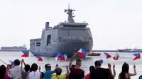 Keluarga awak kapal angkatan laut Filipina melambaikan bendera negara mereka, menyambut kapal baru BRP Davao del Sur di Pelabuhan Selatan Manila, Rabu, 10 Mei 2017 di Manila, Filipina. (AP Photo / Bullit Marquez)
