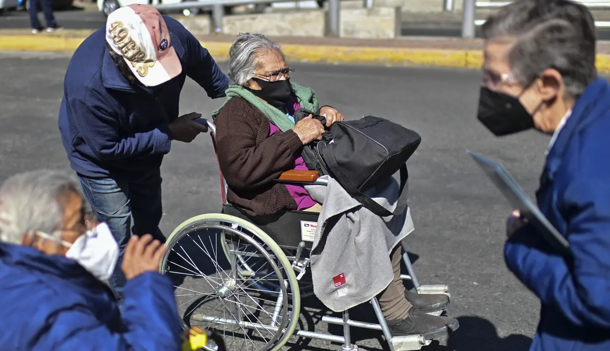 Seorang wanita di kursi roda tiba untuk disuntik dosis ketiga vaksin COVID-19 AstraZeneca di Centro de Estudios Superiores Navales (CENCIS) di Mexico City, Selasa (7/12/2021). Ibu kota Meksiko pada hari Selasa mulai memberikan vaksinasi booster bagi yang berusia di atas 60 tahun. (Pedro PARDO/AFP)