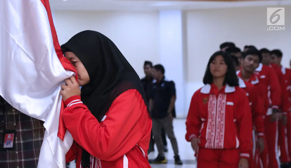 Salah satu atlet pelajar Indonesia untuk Asian School Games 2018 mencium bendera Merah Putih saat upacara pelepasan di Wisma Kemenpora, Jakarta, Selasa (17/7). Asian School Games 2018 berlangsung 19-27 Juli di Malaysia. (Liputan6.com/Helmi Fithriansyah)