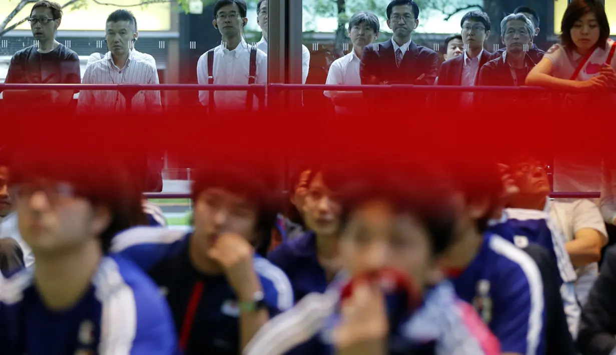 Puluhan warga Jepang di Tokyo tidak kuasa menahan kesedihan saat menyaksikan kekalahan Atsuto Uchida dkk di laga penutup penyisihan Piala dunia 2014 Grup C, (25/6/2014). (REUTERS/Issei Kato) 
