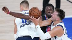 Pebasket Dallas Mavericks, Luka Doncic, berebut bola dengan pemain Los Angeles Clippers, Reggie Jackson, pada gim kedua playoff NBA 2020 di AdventHealth Arena, Kamis (20/8/2020). Maverick menang 127-114 atas LA Clipppers. (AFP/Ashley Landis-Pool/Getty Images)