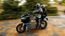 Bram Van Diggelen (kiri) mengendarai motor listrik Storm Eindhoven saat perkenalan di Dubes Belanda di Washington, AS (24/10). Motor ini akan menjalani tur dunia selama 80 hari. (REUTERS/Gary Cameron)