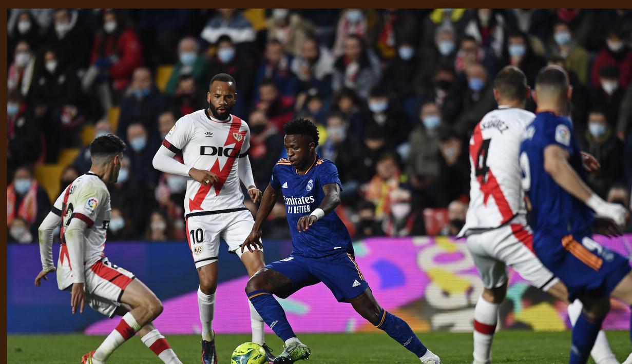 Penyerang Real Madrid, Vinicius Junior (tengah) mencoba menerobos pertahanan Rayo Vallecano pada pertandingan La Liga Spanyol di stadion Vallecas di Madrid, Spanyol, Minggu (27/2/2022). Real Madrid menang tipis atas Rayo Vallecano 1-0. (AP Photo/Jose Breton)