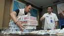 Petugas menata barang bukti kasus transaksi keuangan hasil kejahatan narkotika di Gedung BNN, Jakarta, Selasa (25/10). BNN mengungkap Tindak Pidana Pencucian Uang (TPPU) selama setahun terakhir senilai Rp2,7 triliun. (Liputan6.com/Yoppy Renato)