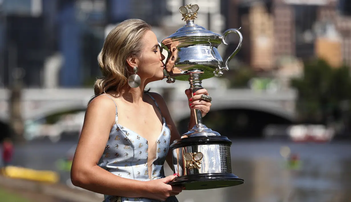 Petenis asal AS Sofia Kenin mencium trofi Australia Terbuka 2020 selama pemotretan di Sungai Yarra, Melbourne, Australia, Minggu, (2/2/2020). Petenis 21 tahun ini tampil cantik mengenakan gaun seksi dengan belahan dada terbuka saat sesi pemotretan tersebut. (AP Photo/Dita Alangkara)