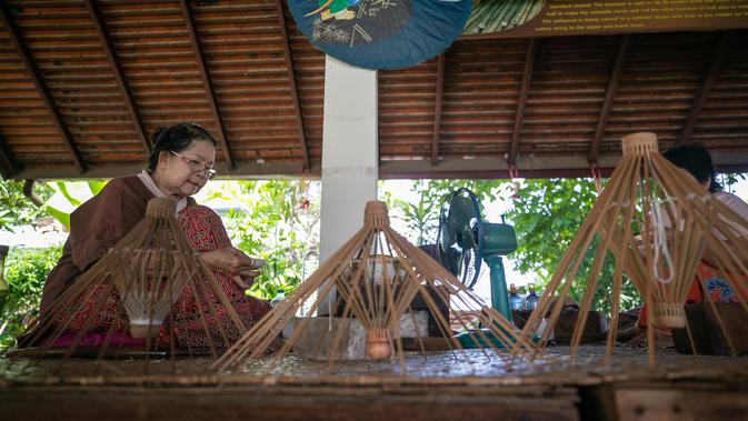 Seorang perajin perempuan membuat kerangka payung di Sentra Pembuatan Payung di Desa Bor Sang, Chiang Mai, Thailand, pada 1 November 2020. Desa Bor Sang, sekitar sembilan kilometer di sebelah timur Kota Tua Chiang Mai, terkenal sebagai daerah pembuat payung kertas. (Xinhua/Zhang Keren)