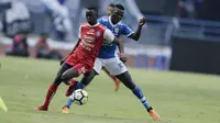 Striker Persib Bandung, Ezechiel N'Douassel, berebut bola dengan gelandang Arema FC, Makan Konate, pada laga Liga 1 di Stadion GBLA, Jawa Barat, Kamis (13/9/2018). Persib menang 2-0 atas Arema FC. (Bola.com/M Iqbal Ichsan)