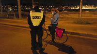 Polisi memeriksa seorang wanita yang mengendarai sepeda selama jam malam dekat Majelis Nasional di Paris, Perancis, Selasa (15/12/2020). Pelanggar jam malam akan dikenakan denda 135 Euro atau sekitar Rp 2,3 juta. (AP Photo/Francois Mori)