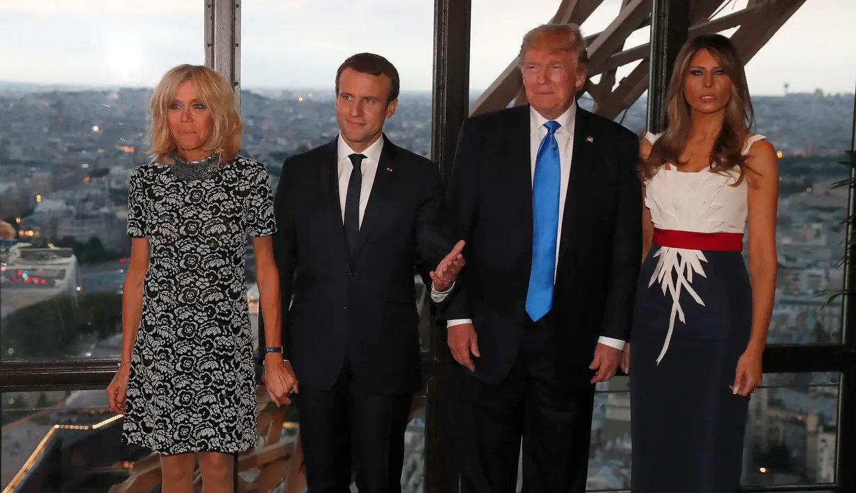 Presiden AS Donald Trump dan Melania serta Presiden Prancis Emmanuel Macron dan Brigitte Macron berfoto sebelum jamuan makan malam di Menara Eifel, Paris, Kamis (13/7). Kunjungan Trump ke Paris merupakan undangan Macron. (Yves Herman/Pool Photo via AP)
