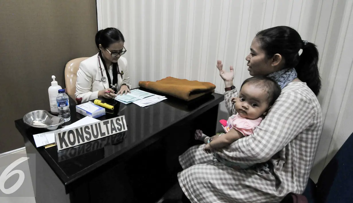 Seorang ibu berkonsultasi dengan dokter sebelum melakukan vaksinasi ulang anaknya di RS Polri Kramatjati, Jakarta Timur, Kamis (21/7). RS Polri Kramatjati buka posko pelayan vaksinasi ulang untuk warga. (Liputan6.com/Yoppy Renato)