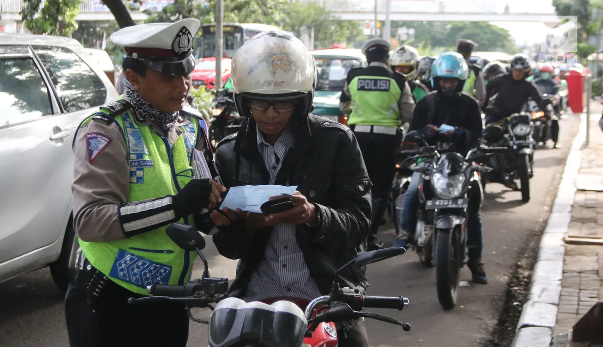 Petugas kepolisian memeriksa kelengkapan surat-surat pengendara bermotor saat Operasi Keselamatan Jaya 2018  di Jalan Letjen Suprapto, Jakarta, Senin (5/3). Dalam operasi hari pertama, Polda Metro menerjunkan 2.704 personel. (Liputan6.com/Arya Manggala)