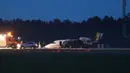 Layanan darurat terlihat di sebelah pesawat Cessna 560XL yang terbakar saat mendarat di Bandara Aarhus di Tirstrup (6/8/2019). Tidak ada korban jiwa akibat kecelakaan pesawat yang terbakar pada pukul 00.38 di malam hari. (Oexenholt Foto/Ritzau Scanpix/AFP)