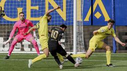 Striker Barcelona, Lionel Messi (tengah) melepaskan tendangan ke gawang Villarreal dalam laga lanjutan Liga Spanyol 2020/2021 pekan ke-32 di The Ceramica Stadium, Villarreal, Minggu (25/4/2021). Barcelona menang 2-1 atas Villarreal. (AP/Alberto Saiz)