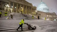 Seorang pekerja membersihkan tumpuhkan salju di AS. (telegraph.co.uk)