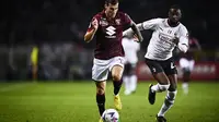 Pietro Pellegri dari Torino, kiri, berlari dengan bola melewati pemain AC Milan Fikayo Tomori selama pertandingan sepak bola Serie A antara Torino dan AC Milan di stadion Olimpiade Turin, Italia Minggu, 30 Oktober 2022. (Fabio Ferrari/LaPresse via AP)