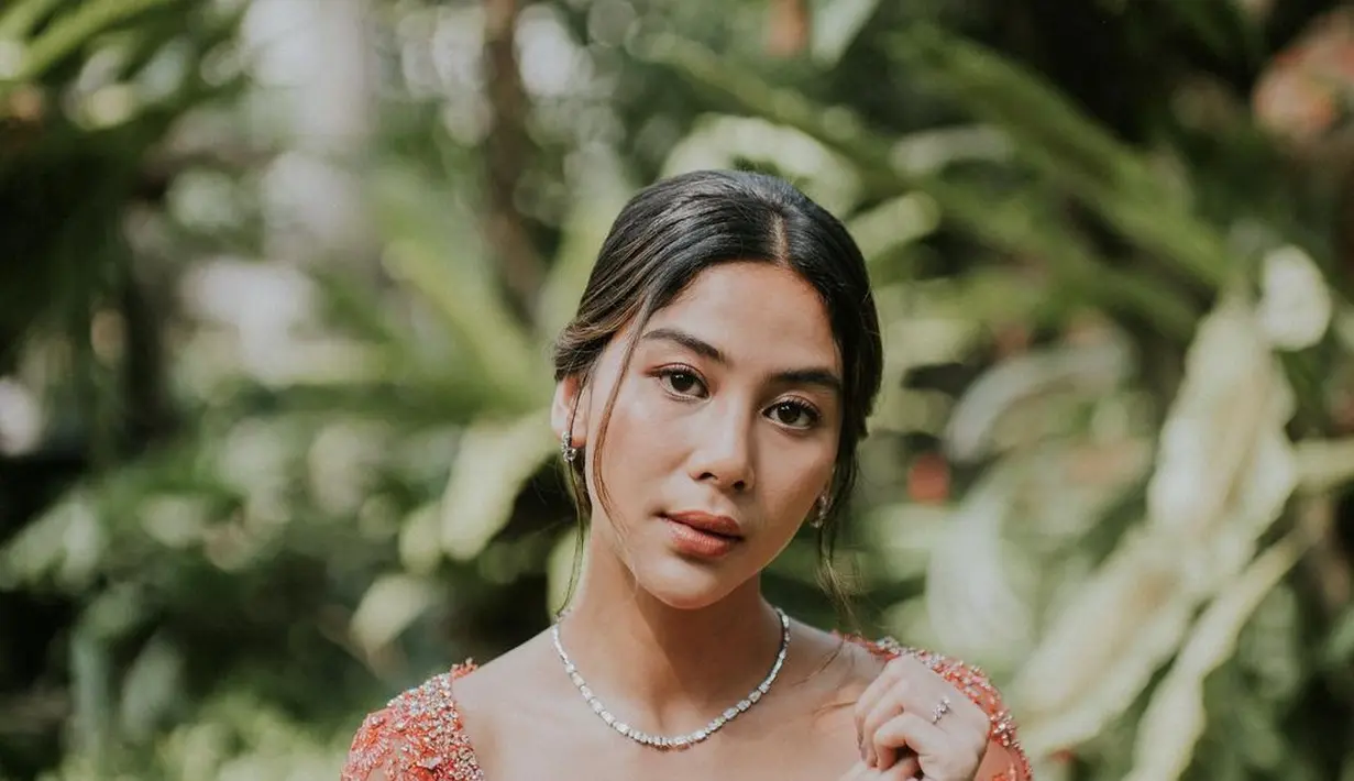 Di hari bahagia itu, Adinda Thomas tampil menawan dalam balutan kebaya brokat asimetris  warna peach cerah lansiran Ayung Berinda. [Foto: IG/@paintedby_kiki/@adindathomas].