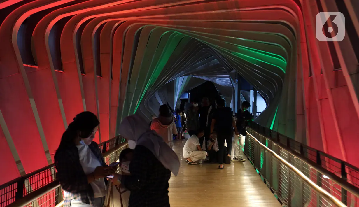 Aktivitas warga di jembatan penyebrangan orang (JPO) Gelora Bung Karno yang berhias lampu berwarna bendera Palestina, Jakarta, Rabu (19/5/2021). Pemprov DKI melakukan aksi solidaritas untuk Palestina dengan menampilkan warna-warna khas bendera Palestina di 10 JPO. (Liputan6.com/Herman Zakharia)