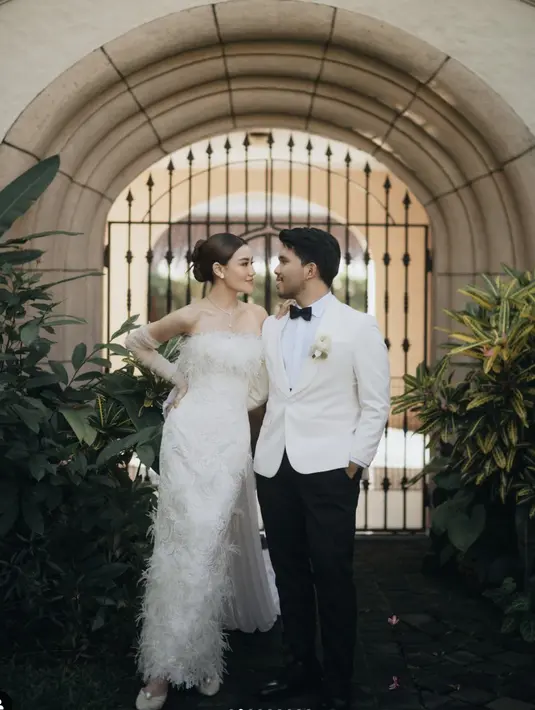 Aaliyah mengenakan gaun putih dengan aksen bulu, sedangkan Thariq kenakan tuksedo beige dengan dasi hitam. [Foto: Instagram/ Aaliyah Massaid]