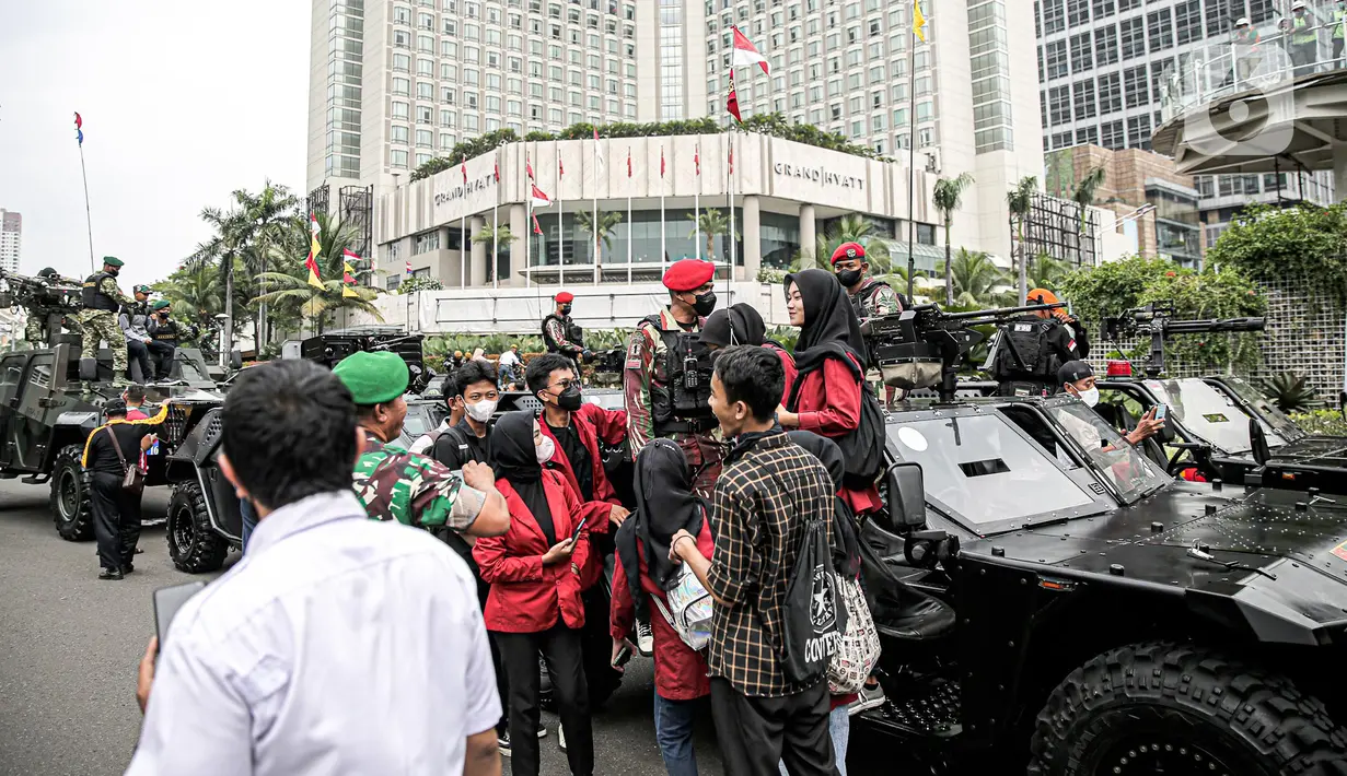 Warga berfoto dengan tentara dan alat utama sistem senjata (alutsista) milik TNI saat perayaan HUT ke-77 TNI di Bundaran HI, Jakarta, Rabu (5/10/2022). Kegiatan yang diikuti oleh seluruh kesatuan jajaran TNI ini dalam rangka menyambut HUT ke-77 TNI. (Liputan6.com/Faizal Fanani)