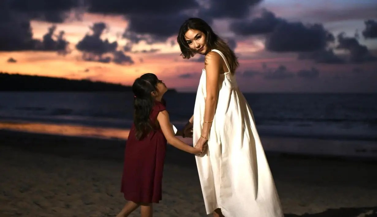 Menyambut Natal, Gisel menikmati suasana pinggir pantai bersama Gempi. Mengenakan asimetris dress berwarna putih, Gisel tampil cantik saat menari bersama Gempi.