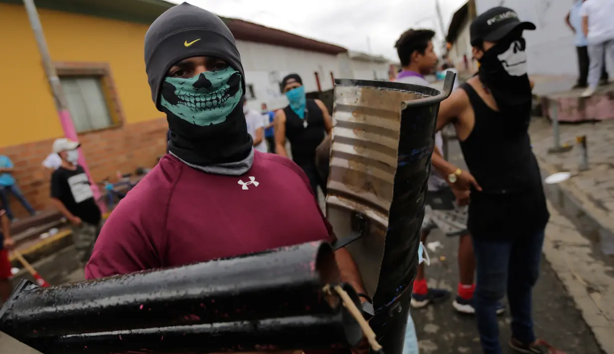 Seorang demonstran membawa tameng dan mortir rakitan di kota Masaya, Nikaragua (5/6). Akibat aksi dan bentrokan yang dimulai sejak 18 April tersebut, setidaknya 121 orang telah tewas. (AFP/Inti Ocon)