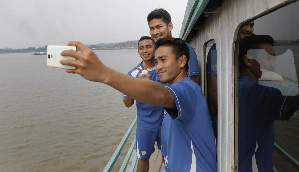 Sejumlah punggawa Persib melakukan selfie saat melintasi Sungai Mahakam menuju Stadion Aji Imbut, Tenggarong, Kaltim, Sabtu (3/10/2015). (Bola.com/Vitalis Yogi Trisna)