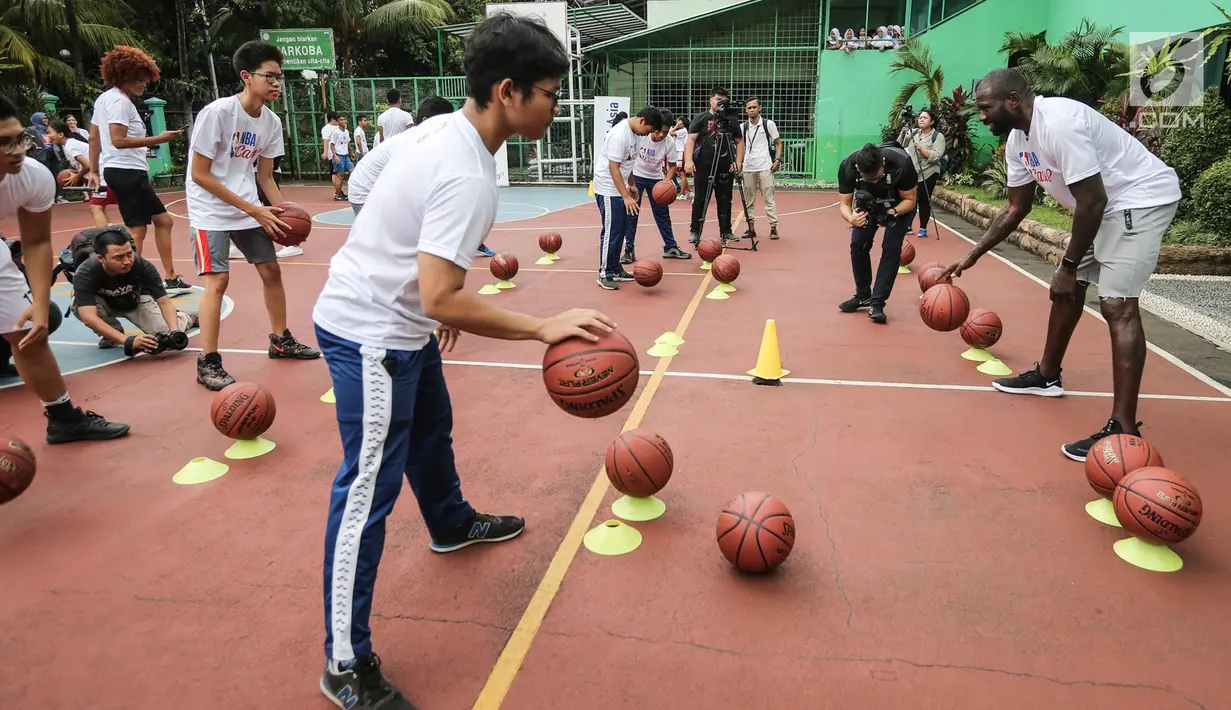 Mantan pemain NBA Jason Richardson melatih siswa-siswi pada program coaching clinic dan NBA Cares yang digelar Jr. NBA Indonesia di SMAN 82 Jakarta, Kamis (28/9). Jason Richardson merupakan Juara kontes slam dunk NBA 2002 dan 2003. (Liputan6.com/Fery Pradolo)