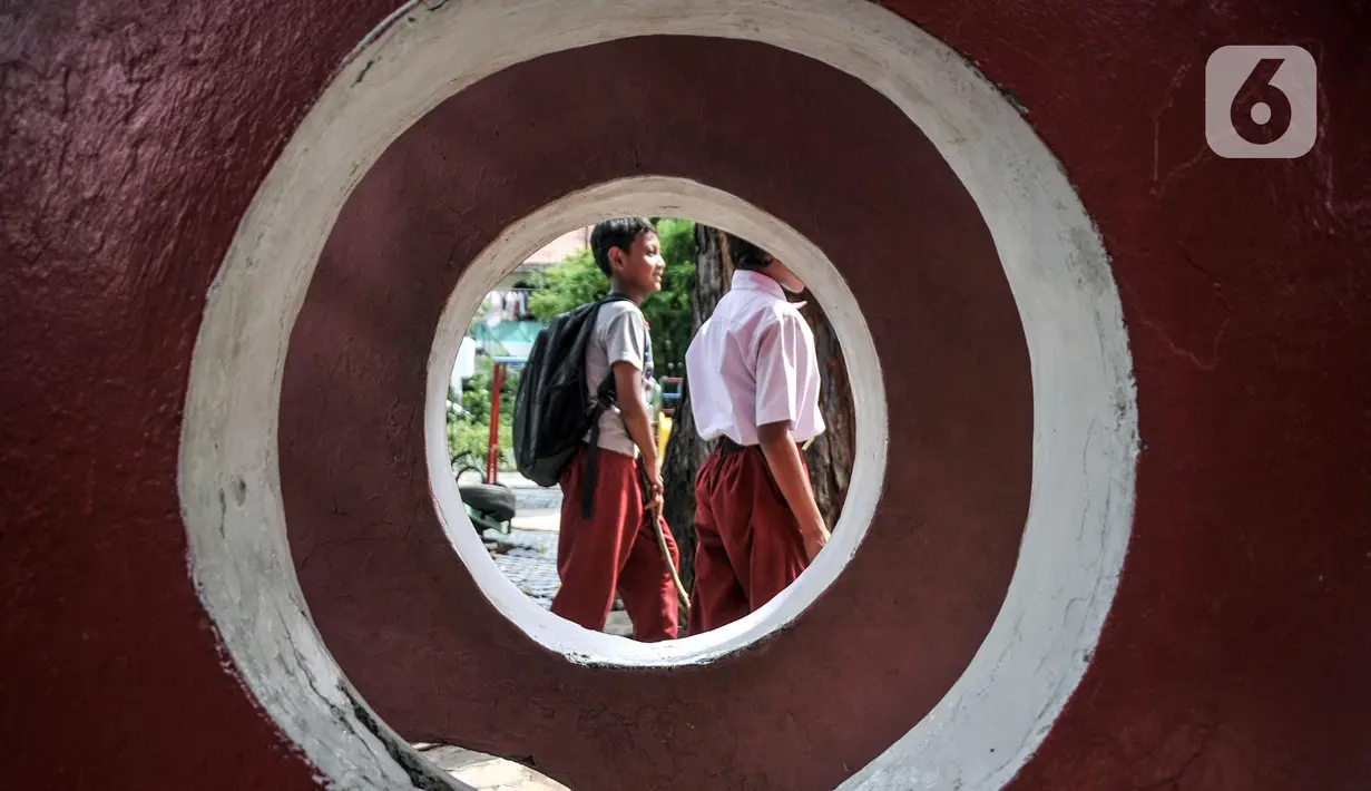 Sejumlah siswa sekolah berjalan di Ruang Publik Terpadu Ramah Anak (RPTRA) Manggis, Kelurahan Kemanggisan, Kecamatan Palmerah, Jakarta Barat, Senin (31/10/2022). Minimnya pengawasan oleh pihak terkait menyebabkan kondisi sejumlah wahana bermain di RPTRA Manggis yang dibangun era Gubernur DKI Jakarta Basuki Tjahaja Purnama alias Ahok itu kini dalam kondisi rusak dan tak terawat. (merdeka.com/Iqbal S. Nugroho)