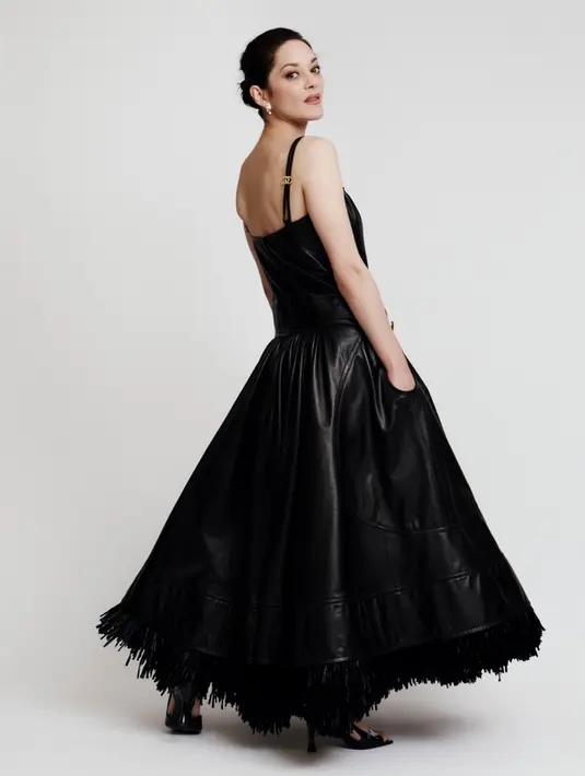 Marion Cotillard tampil paling bold lewat gaun hitam berbahan leather dengan siluet ball gown dramatis. Dress berpotongan fitted di bagian atas lalu melebar megah di bagian rok menciptakan statement look yang theatrical namun tetap elegan. [Dok/Chanel].