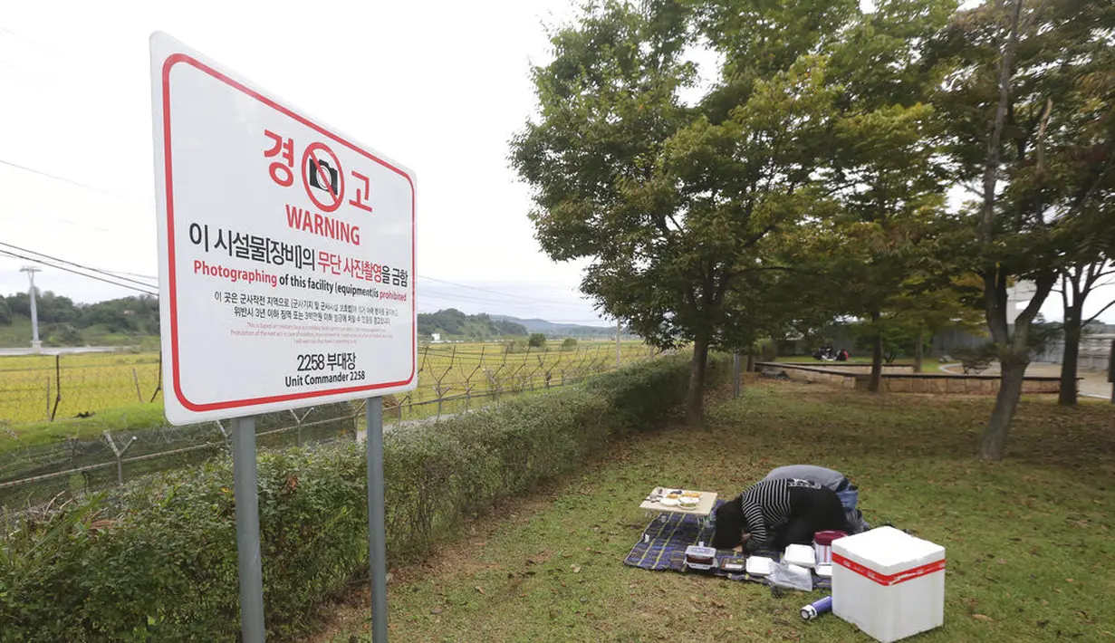 Anggota keluarga pengungsi Korea Utara membungkuk untuk menghormati leluhur mereka di Korea Utara saat merayakan Chuseok dekat perbatasan dengan Korea Utara di Paviliun Imjingak, Paju, Selatan Korea, Kamis (1/10/2020). (AP Photo/Ahn Young-joon)