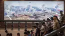 Foto yang diambil 24 Juli 2017. Pengunjung melintas di depan lukisan yang menunjukkan sejumlah tank saat berperang di Sinchon Museum of American War Atrocities, Sinchon, Pyongyang. Museum ini didedikasikan kepada Pembantaian Sinchon. (AFP Photo/Ed Jones)