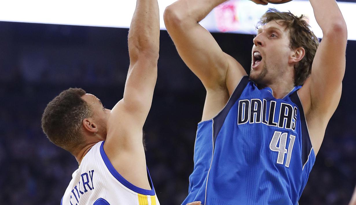 Pemain Dallas Mavericks, Dirk Nowitzki #41 melakukan tembakan saat dibayangi pemain Golden State Warriors, Stephen Curry #30 pada laga NBA basketball game  di Oakland, California, (30/12/2016). Warriors menang 108-99. (AP/Tony Avelar)