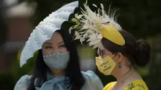 Anna Gilder (kanan) bersama Yuan Li berpose untuk fotografer mengenakan topi hiasan mereka pada hari pertama pacuan kuda Royal Ascot di Ascot, Inggris, Selasa (15/6/2021). Balap kuda eksklusif yang hanya dihadiri kalangan elit Inggris itu menjadi tradisi tahunan sejak 1711. (AP Photo/Alastair Grant)