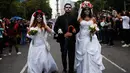 Peserta berdandan ala tengkorak saat mengikuti parade Hari Orang Mati di Mexico City, Meksiko, Sabtu (26/10/2019. Para peserta dalam parade ini mengenakan kostum dan melukis wajah mirip dengan tokoh tengkorak Meksiko yang ikonik, Catrina. (AP Photo/Ginnette Riquelme)