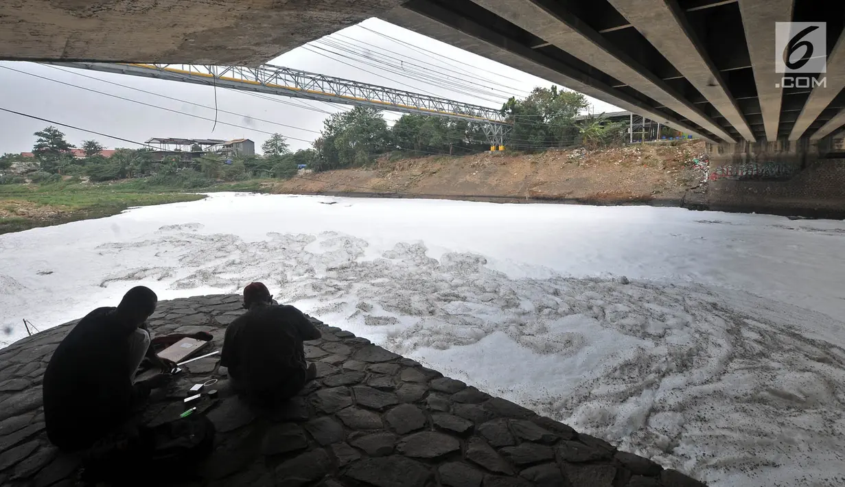 Petugas Dinas Pertamanan bekerja di atas Kali Bekasi yang tercemar limbah busa di kawasan Marga Jaya, Bekasi, Kamis (18/10). Selain limbah busa, air Kali Bekasi juga berubah menjadi hitam pekat dan dipenuhi sampah. (Merdeka.com/Iqbal S. Nugroho)