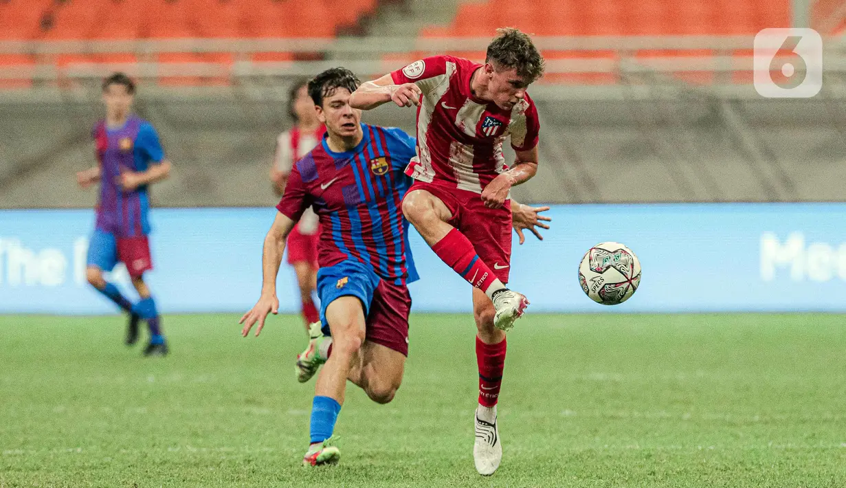 Pemain Altetico Madrid U-18  berebut bola dengan pemain Barcelona U-18 pada pertandingan International Youth Championship (IYC) 2021 di Jakarta International Stadium (JIS), Jakarta, Selasa (19/4/2022). Barcelona U-18 menang 1-0. (Liputan6.com/Faizal Fanani)