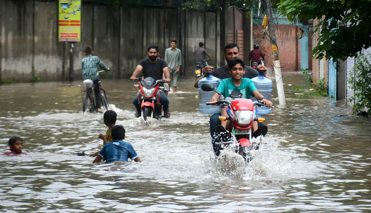 Warga mengendarai sepeda motor di jalanan yang terendam banjir setelah hujan lebat mengguyur Lahore, Punjab, Pakistan, 20 Agustus 2020. Sebanyak 18 orang tewas dan banyak lainnya terluka akibat hujan lebat di Punjab. (Xinhua/Sajjad)