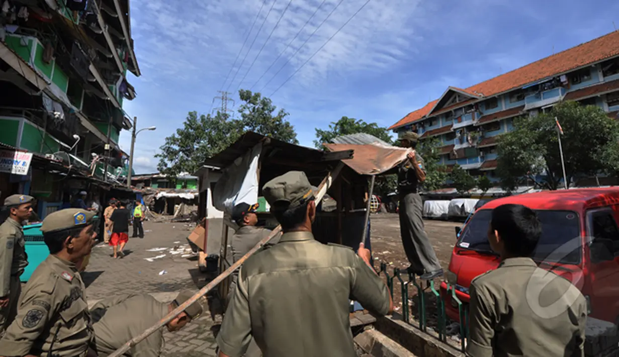 Sejumlah petugas satpol PP membongkar bangunan liar di kawasan rusun tanah tinggi, Jakarta, Rabu (4/3/2015).  Sebanyak 10 bangunan liar di Rumah Susun (Rusun) Tanah Tinggi ditertibkan aparat satpol PP. (Liputan6.com/Faizal Fanani)
